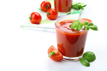 Glasses of fresh tomato juice on checkered napkin, isolated on white