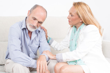 Obraz premium Ältere Frau tröstet ihren Partner auf dem Sofa