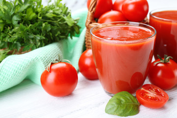 Glasses of fresh tomato juice on wooden table, closeup