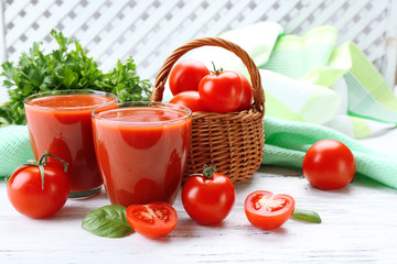 Glasses of fresh tomato juice on wooden table, closeup