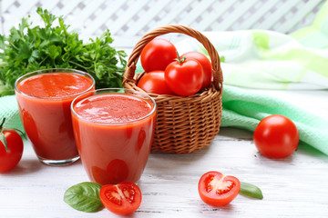 Glasses of fresh tomato juice on wooden table, closeup