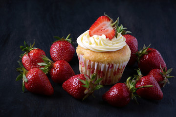 Capcakes with strawberries on dark background