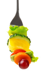 Snack of vegetables on fork isolated on white