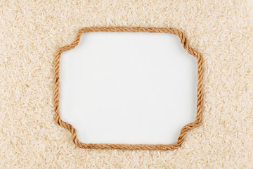 Figured frame made of rope with rice grains  lying on a white ba