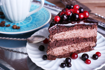 Delicious chocolate cake with berries on plate on table close up