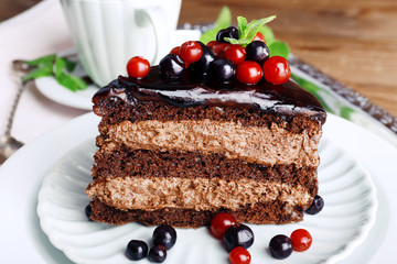 Delicious chocolate cake with berries on plate on table close up