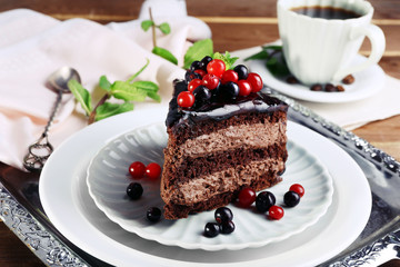 Delicious chocolate cake with berries on plate on table close up