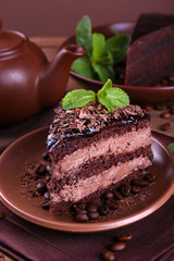 Delicious chocolate cake with mint on plate on table close up