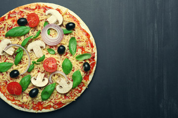 Raw pizza with vegetables on wooden background