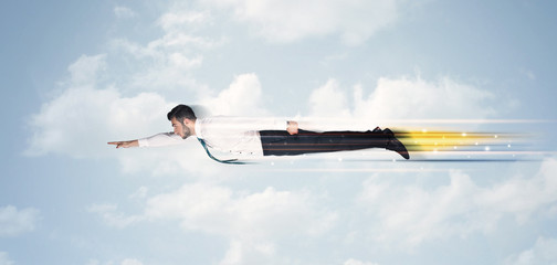 Happy business man flying fast on the sky between clouds