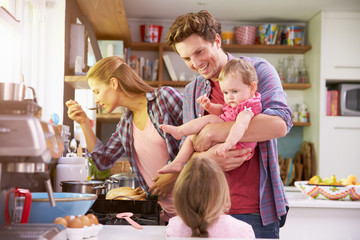 Family Cooking Meal In Kitchen Together