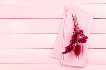 Beautiful dry flowers on napkin on wooden background