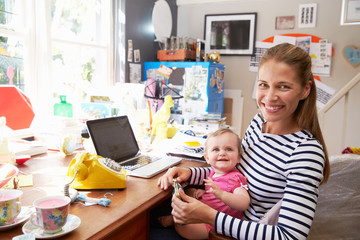 Mother With Daughter Running Small Business From Home Office