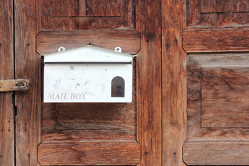 White mail box on old wooden door.
