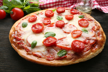 Delicious pizza with cheese and cherry tomatoes on wooden table, closeup