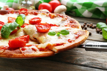 Delicious pizza with cheese and cherry tomatoes on wooden table, closeup
