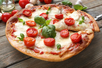 Delicious pizza with cheese and cherry tomatoes on wooden table, closeup