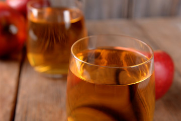 Glasses of apple juice on wooden table, closeup