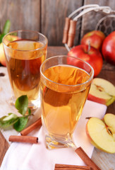 Glasses of apple juice on wooden table, closeup