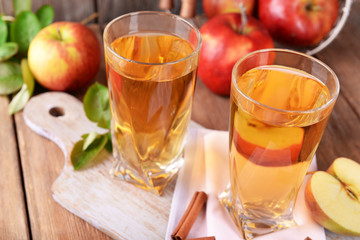 Glasses of apple juice on wooden table, closeup