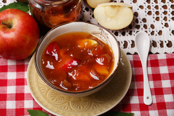 Apple jam and fresh red apples on wooden table close-up