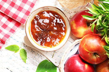 Apple jam and fresh red apples on wooden table close-up
