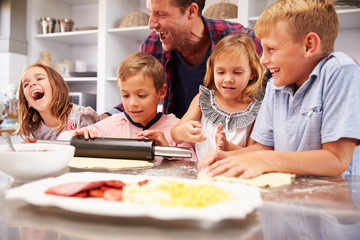 Father making pizza with his kids