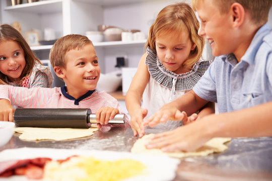 Children making pizza together