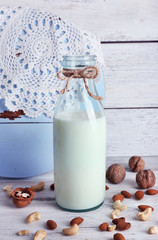 Milk in glassware and walnuts on wooden background