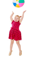 Joyful little girl jumps high for an inflatable ball