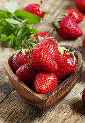 Fresh organic strawberries in a bowl in the shape of a heart, se