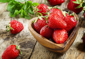 Fresh organic strawberries in a bowl in the shape of a heart, se