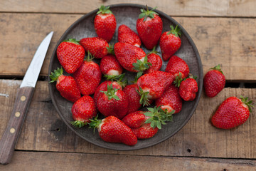 Erdbeeren in alter Waagschale auf Holz
