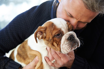 Mature Man Holding English Bulldog Puppy