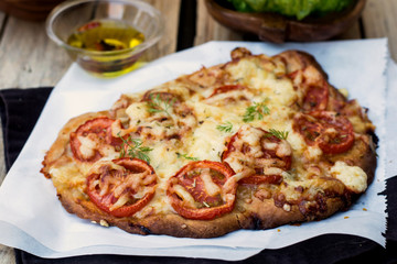 Pizza style pie with tomatoes, cheese and herbs