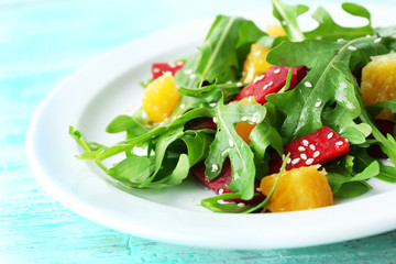Tasty salad with arugula leaves in plate, closeup