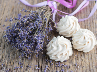 Bouquet of dry lavender and meringue on an old wooden table
