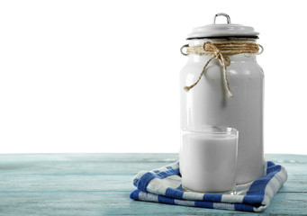 Retro can for milk and glass of milk on wooden table, on white background