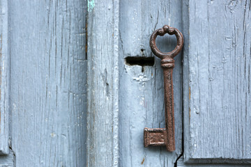 Old key on wooden antique door close-up