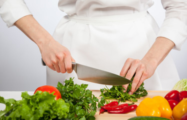 Cook's hands preparing salad