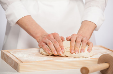 Obraz na płótnie Canvas Female cook kneading dough