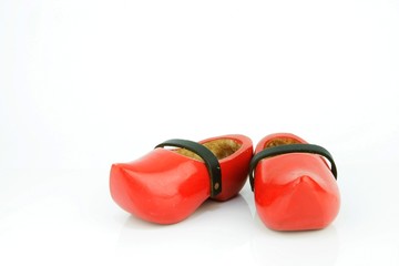 Red wooden shoes / Dutch clogs with a black leather strap. Traditional Dutch footwear for farmers.