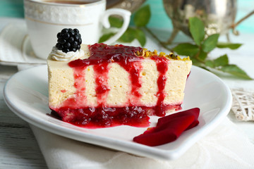 Tasty piece of cheesecake with berry sauce on plate on table close up