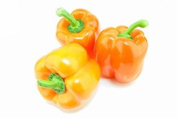 A group of fresh orange paprika (Capsicum annuum) on a white background.