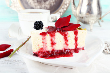 Tasty piece of cheesecake with berry sauce on plate on table close up
