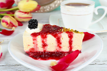Tasty piece of cheesecake with berry sauce on plate on table close up