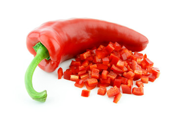 A single red sweet pointy pepper(capsicum) with a diced one in front of it