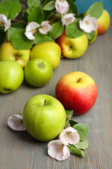 Fresh apples with apple blossom on wooden table