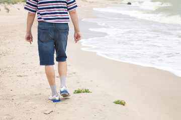 Man walks on the sea beach