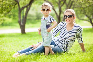 Portrait of a beautiful young woman with a small child in park